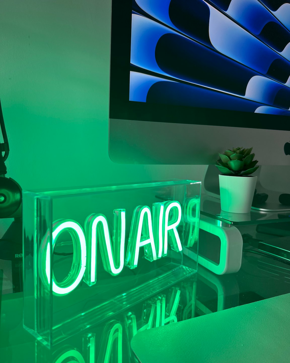 Neon ON AIR sign sitting on a desk.